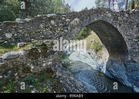 Mittelalterlichen venezianischen Brücke in die Schlucht zwischen den Felsen am sonnigen Frühling Abend. Zypern Brücke Elia. Stockfoto