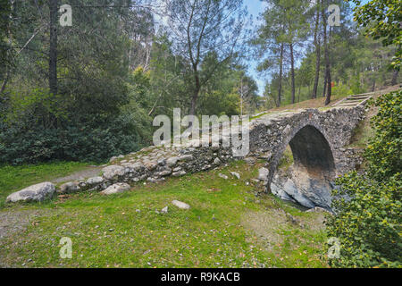 Mittelalterlichen venezianischen Brücke in die Schlucht zwischen den Felsen am sonnigen Frühling Abend. Zypern Brücke Elia. Stockfoto