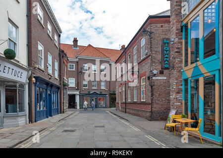 Alten Ziegel Gebäuden, Geschäften und Restaurants auf der Gasse zurück Swinegate im historischen Viertel der Stadt York, England, Großbritannien Stockfoto