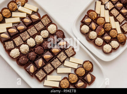 Kleine Schokolade und Vanille geschichteten Kuchen in den Zeilen auf Süßigkeit Buffet. Süße Paradies. Ansicht von oben. Stockfoto