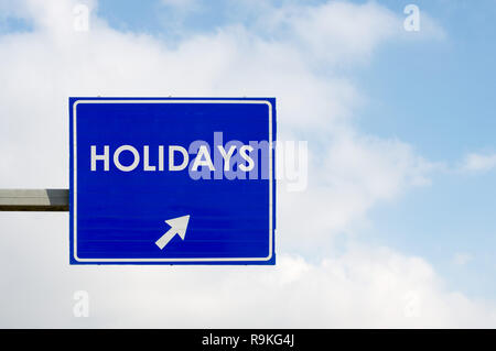 Blaue Schild anzeigen Urlaub Wort auf blauen Himmel und weißen Wolken Hintergrund Stockfoto