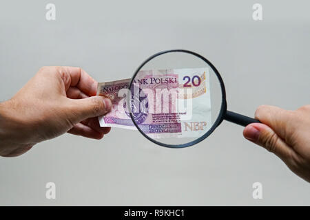 Experte mit Lupe überprüft verdächtige Geld. suche Wasserzeichen auf Papier der gefälschten Rechnungen. Lupe, Lupe, Lupe, magn Stockfoto