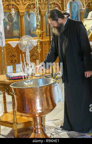 Griechisch-orthodoxen Priester führt den Service in der byzantinischen Kirche in Thassos Stadt auf der Insel Thassos, Griechenland Stockfoto