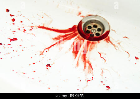 Blut ablassen von weißen Badezimmer Waschbecken. Blutige Flecken auf dem waterbasin Loch. Waschbecken mit Blut überschwemmt. Rote Farbe dripples zu den Waschbecken ablassen. Stockfoto