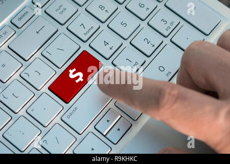 Die Hand des Business Mann drückt auf der Tastatur mit abstrakten Dollarzeichen, ein männlicher Finger drückt eine Taste Farbe Grau Silber Tastatur eines modernen Laptop. Stockfoto