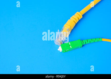 Fibre optische und Netzwerk RJ-45-Kabel auf blauem Hintergrund Stockfoto