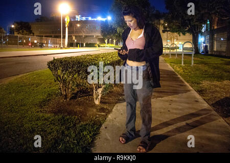 Eine freigegebene county Gefängnisinsassen verwendet eine gespendete Handy für eine Fahrt in der Nacht in Santa Ana, CA. Stockfoto