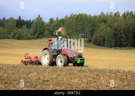 Salo, Finnland - 21 September, 2018: Landwirt pflegt geerntet Stoppeln Feld mit Valtra Traktor und Grubber Horsch Terrano 3 FX im Herbst. Stockfoto