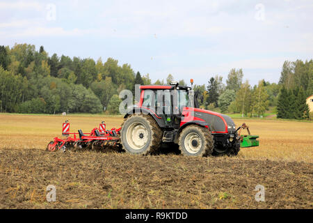 Salo, Finnland - 21 September, 2018: Landwirt pflegt geerntet Stoppeln Feld mit Valtra Traktor und Grubber Horsch Terrano 3 FX im Herbst. Stockfoto