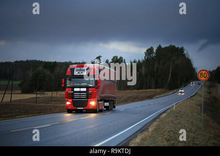 Salo, Finnland - 8. Dezember 2017: Rot DAF XF exklusive edition Auflieger Hols waren unter dunklen Himmel entlang der Landstraße im Süden Finnlands. Stockfoto