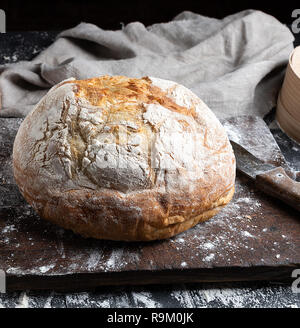 Ganze gebackene runde Brot aus weissem Mehl von Weizen auf einem Holzbrett gemacht Stockfoto