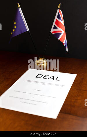 Brexit Konzept. Blatt Papier unter der Leitung 'Deal' auf einem Tisch mit Tischplatte UK- und EU-Flaggen hinter Stockfoto