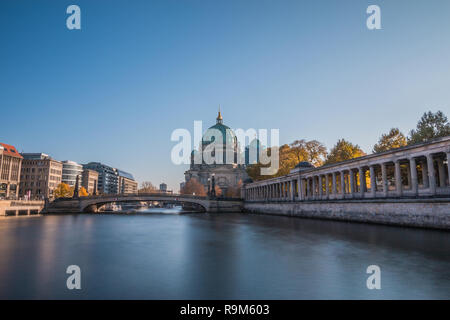 Berliner Dom mit der Friedrich Brücke am blauen Himmel. Arcade der Nationalgalerie am Ufer der Spree mit Gebäuden. Stockfoto