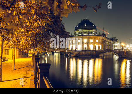 Museumsinsel in der Nacht in das Zentrum von Berlin. herbstliche Stimmung an der Spree mit Brücke. Beleuchtete Pfad am Ufer der Spree mit Bäumen. Stockfoto