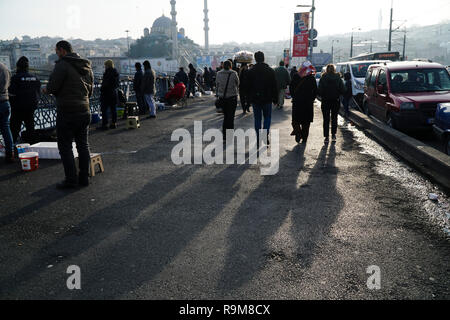 Istanbul, Türkei - 22 Dezember, 2018: Einige türkische Menschen sind zu Fuß auf der Galata-brücke mit schönen Schatten, andere sind Angeln. Stockfoto