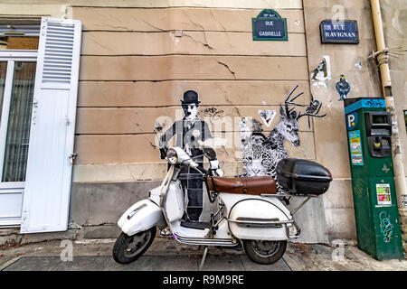 Einen Roller vor einem Straße Malerei von Charlie Chaplin geparkt auf einem an der Wand eines Gebäudes in Montmartre, Paris Stockfoto