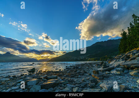 Sonnenstrahlen auf Sonnenuntergang am Lake Wakapitu in Queenstown, Südliche Alpen, Otago, Neuseeland Stockfoto