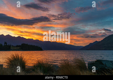 Afterglow nach Sonnenuntergang mit roter Himmel über den Lake Wakatipu, Queenstown, Otago, Neuseeland Stockfoto