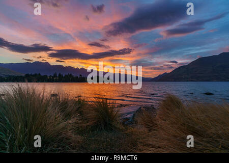 Afterglow nach Sonnenuntergang mit roter Himmel über den Lake Wakatipu, Queenstown, Otago, Neuseeland Stockfoto