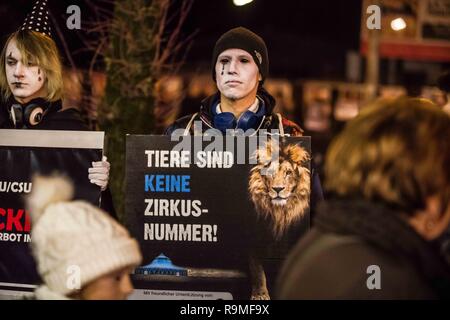 München, Bayern, Deutschland. 25 Dez, 2018. Entsprechende mit der Eröffnung der Münchner Circus Krone Winterprogramm, Tierschützer von der Aktionsgruppe Tierrechte Bayern organisierte ein Protest als traurige Clowns zu protestieren, was sie, als das Unternehmen über 100 Jahre Tierquälerei. Der Zirkus wird sein 100-jähriges Bestehen im Jahr 2019 feiern die Münchner Circus Krone ist das einzige ständige Zirkus Installation in den deutschsprachigen Regionen Europas mit über 3.000 Plätzen. Das Unternehmen hält auch verschiedene Konzerte, die von großen internationalen touring Künstler, Kabarett, und verschiedene o Stockfoto