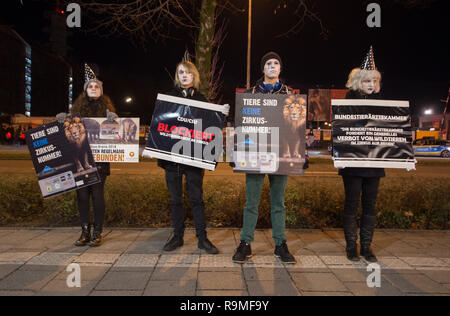 München, Bayern, Deutschland. 25 Dez, 2018. Entsprechende mit der Eröffnung der Münchner Circus Krone Winterprogramm, Tierschützer von der Aktionsgruppe Tierrechte Bayern organisierte ein Protest als traurige Clowns zu protestieren, was sie, als das Unternehmen über 100 Jahre Tierquälerei. Der Zirkus wird sein 100-jähriges Bestehen im Jahr 2019 feiern die Münchner Circus Krone ist das einzige ständige Zirkus Installation in den deutschsprachigen Regionen Europas mit über 3.000 Plätzen. Das Unternehmen hält auch verschiedene Konzerte, die von großen internationalen touring Künstler, Kabarett, und verschiedene o Stockfoto