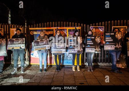 München, Bayern, Deutschland. 25 Dez, 2018. Entsprechende mit der Eröffnung der Münchner Circus Krone Winterprogramm, Tierschützer von der Aktionsgruppe Tierrechte Bayern organisierte ein Protest als traurige Clowns zu protestieren, was sie, als das Unternehmen über 100 Jahre Tierquälerei. Der Zirkus wird sein 100-jähriges Bestehen im Jahr 2019 feiern die Münchner Circus Krone ist das einzige ständige Zirkus Installation in den deutschsprachigen Regionen Europas mit über 3.000 Plätzen. Das Unternehmen hält auch verschiedene Konzerte, die von großen internationalen touring Künstler, Kabarett, und verschiedene o Stockfoto