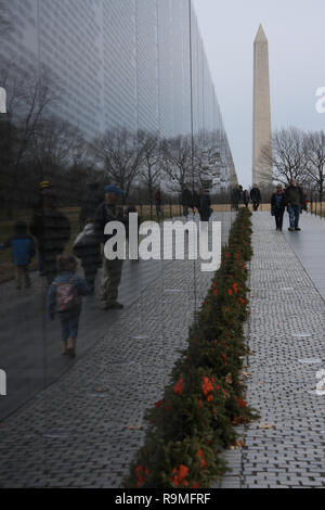 Washington, DC, USA. 25 Dez, 2018. Kränze können gesehen werden entlang der Vietnam Veterans Memorial Wall am Weihnachtstag in Washington, DC. Das Washington Monument im Hintergrund gesehen werden. Credit: Evan Golub/ZUMA Draht/Alamy leben Nachrichten Stockfoto