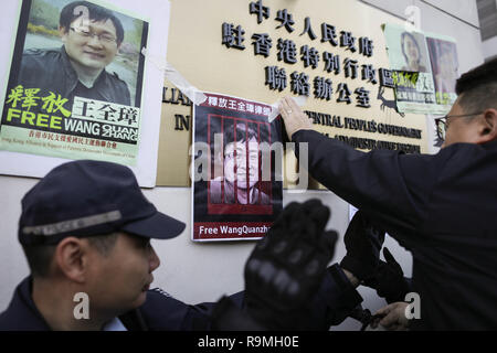 Hongkong, China. 26. Dezember, 2018. Eine Demonstrantin gesehen hängt ein Poster von Wang Quanzhang auf der China Liaison Office Gebäude während der Demonstration. Aktivisten und politische Gruppen kommen an der China Liaison Office in Hongkong das harte Vorgehen gegen die Menschenrechtsanwälte in China zu protestieren. Im Jahr 2015, über 200 Anwälte und Dissidenten inhaftiert wurden allgemein als "709" Durchgreifen bekannt, auf denen, die bürgerlichen Rechte fällen als empfindlich von den chinesischen Behörden ergriffen haben. Credit: SOPA Images Limited/Alamy leben Nachrichten Stockfoto