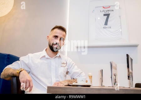 Berlin, Deutschland. 19 Dez, 2018. Benjamin Köhler, Inhaber der Eisdiele La Luna, sitzt an einem Tisch in seiner Eisdiele in der Ostseite Mall, mit einem seiner 1. FC Union Berlin Trikots an der Wand hängen. (Dpa 'Zwei Welten': Das neue Leben von Benjamin Köhler" vom 27.12.2018) Quelle: Christoph Soeder/dpa/Alamy leben Nachrichten Stockfoto