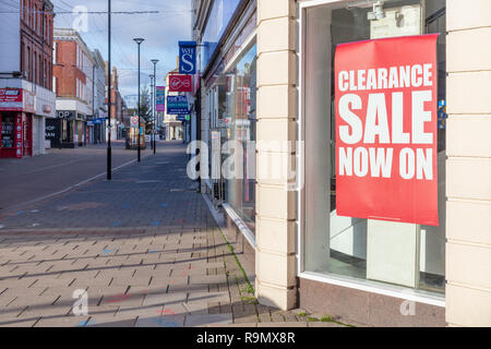 Worthing in Sussex, UK; 25. Dezember 2018; Große Rote Verkauf Zeichen im Schaufenster. Leere High Street in die Ferne Stockfoto