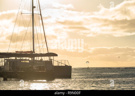 Katamaran angedockt am Waikiki Strand bei Sonnenuntergang in Honolulu, Hawaii Stockfoto