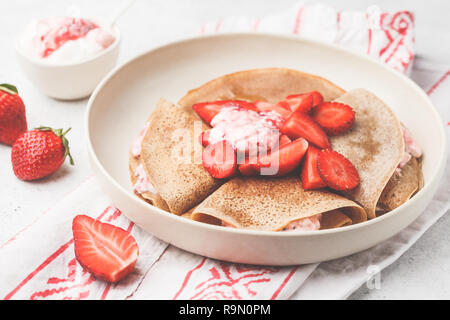 Pfannkuchen mit Erdbeeren und Joghurt, weißer Hintergrund, Ansicht von oben. Frühstück Konzept. Stockfoto