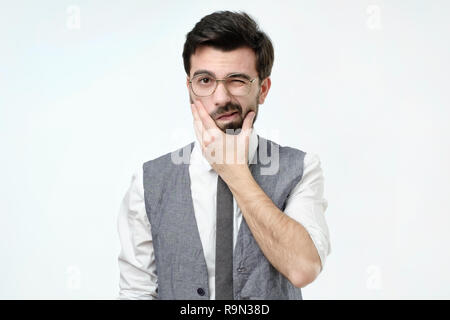 Zweifelnd bärtige junge spanische Mann, mit Misstrauen. Stockfoto