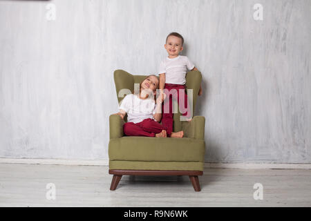 Junge und Mädchen sind Bruder und Schwester sitzen auf einem grünen Couch im Zimmer Stockfoto