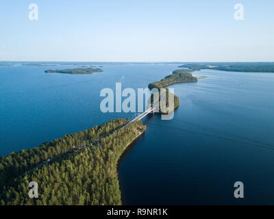 Malerische Ridge Road mit einer Brücke über einem See in Finnland. Luftaufnahme. Stockfoto