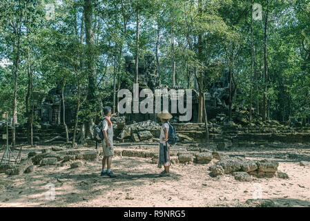 Touristische Paar besuchen Angkor Tempel, Kambodscha. Ta Nei Gebäude Ruinen im Dschungel. Umweltfreundliche Tourismus Reisen, getönten Bild. Stockfoto