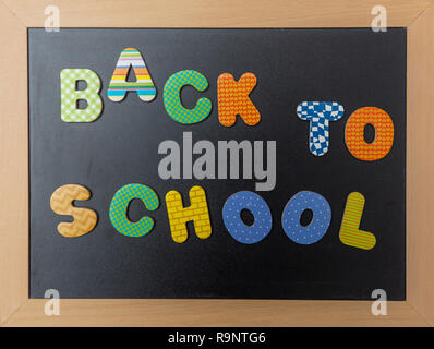 Schule Konzept. Schwarze Schiefertafel mit Holzrahmen, Text zurück zu Schule in bunten Buchstaben Stockfoto