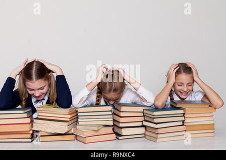 Drei Mädchen Schülerinnen an einem Schreibtisch mit Büchern über die Lektion in der Schule Stockfoto