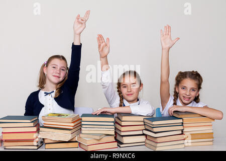 Drei Schülerinnen Mädchen in der Klasse am Schreibtisch mit Büchern zu beantworten Stockfoto