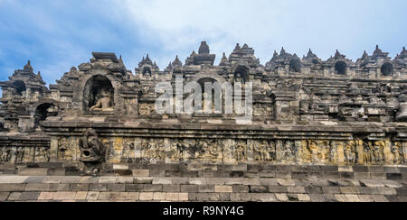 Anzeigen von bas-relief Galerien und zahlreiche Buddha staues in Nischen von der Basis Terrasse von Borobudur buddhistischen Tempel untergebracht, Zentraljava, Indonesien Stockfoto