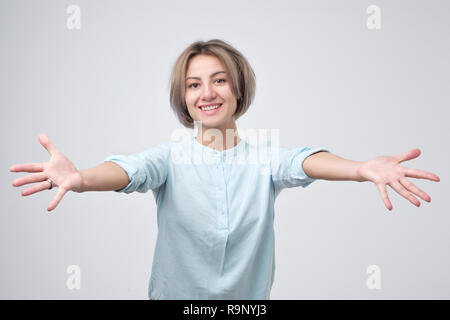 Schöne junge Frau in Blau Hemd mit einer Umarmung Stockfoto