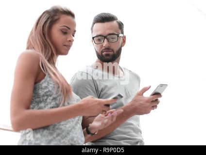 Junges Paar an die Bildschirme von ihren Smartphones suchen Stockfoto