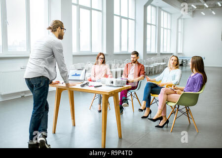 Mann, wie ein Sprecher der Berichterstattung an das junge Publikum während der Sitzung im Konferenzraum Stockfoto