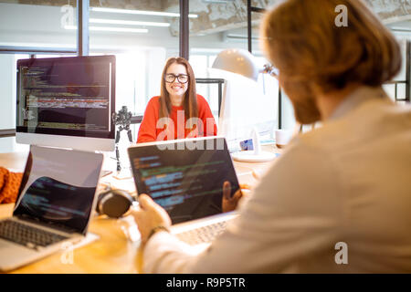 Ein Team von jungen Programmierern gekleidet beiläufig Arbeiten am Computer code sitzt im modernen Büro innen Stockfoto