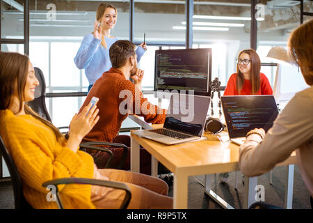 Ein Team von jungen Programmierern gekleidet beiläufig Arbeiten am Computer code sitzt im modernen Büro innen Stockfoto