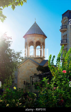 Alten Kirchturm der Kirche in Tiflis, Georgien und den schönen Garten. Strahlender Sonnenschein. Stockfoto