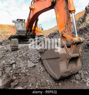 Bagger graben und Laden von Erz Felsen auf ein Mangan mine Stockfoto