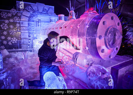 Großbritanniens erste Eis Dorf in Manchester, ein Bildhauer, arbeitet an einer Dampflok Lok Skulptur Stockfoto