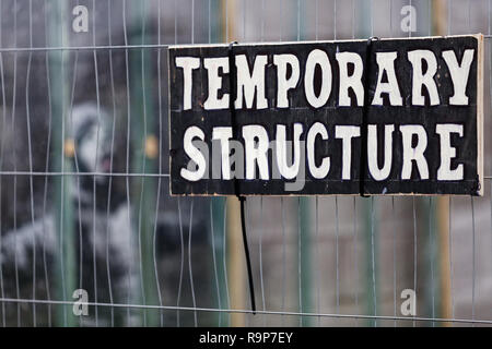 Im Bild: Eine 'Temporäre Struktur' Zeichen auf dem Zaun zum Schutz der Banksy graffiti auf einer Garage in Port Talbot, Wales, UK. Dienstag, 25 Dezember 2018 Re: Stockfoto