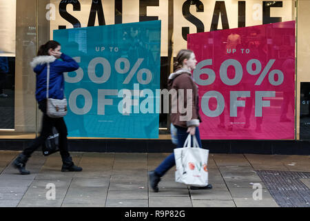 Letzte Weihnachtskäufer Spaziergang, vorbei an einem "60% OFF"-Schild draußen Topshop Store in der Oxford Street, Swansea, Wales, UK. Montag, 24 Dezember 2018 Stockfoto